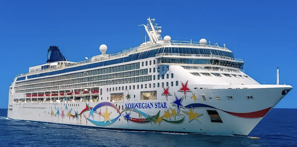 Norwegian Star cruise ship underway, hull painted with its signature ribbon-and-stars livery